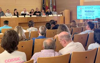 Representantes de APEMYF y Sindicato Médico Avanza, sentados en la mesa principal de un seminario en Vigo, con público asistente y una pantalla que anuncia la jornada dedicada a la defensa del Estatuto Médico.
