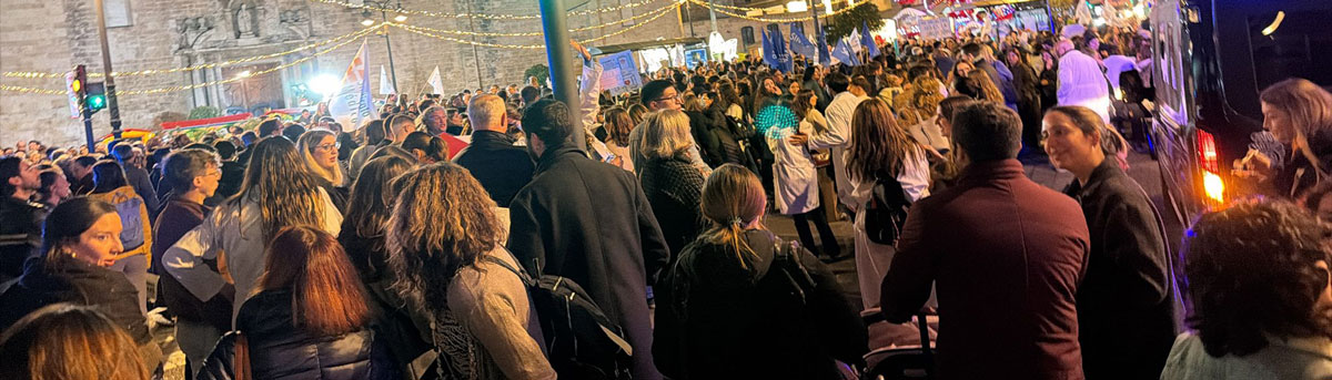 Multitud avanza en una manifestación nocturna por mejoras sanitarias y condiciones laborales en València.